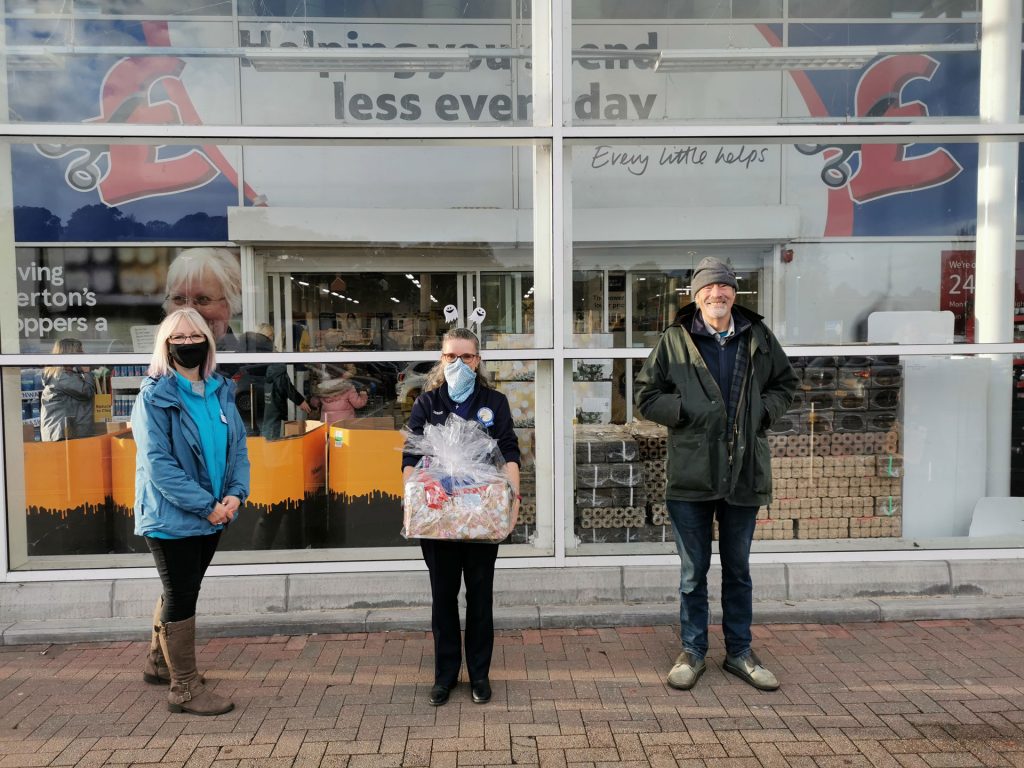 Three people standing socially distanced in front of Tesco