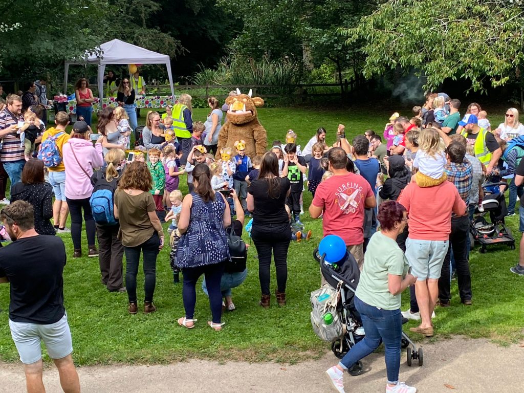 A group of people clustered around a Gruffalo