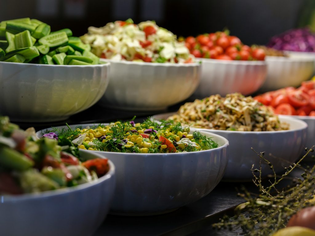 White bowls of different salads