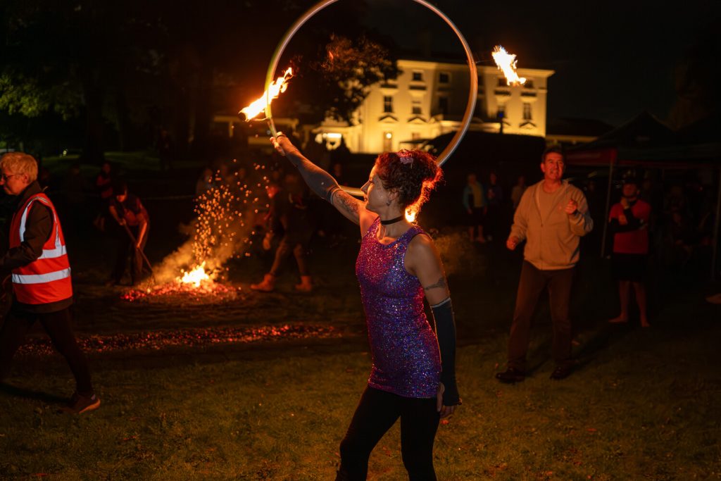 A fire performer with a flaming hoop