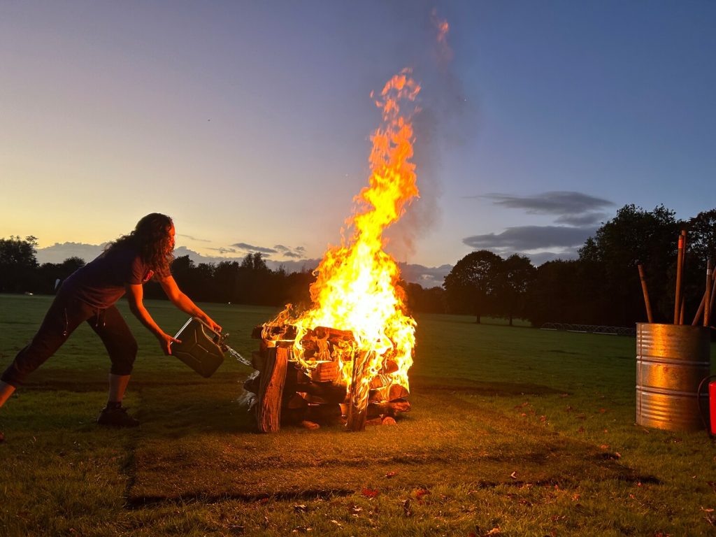 A woman adding fuel to a fire