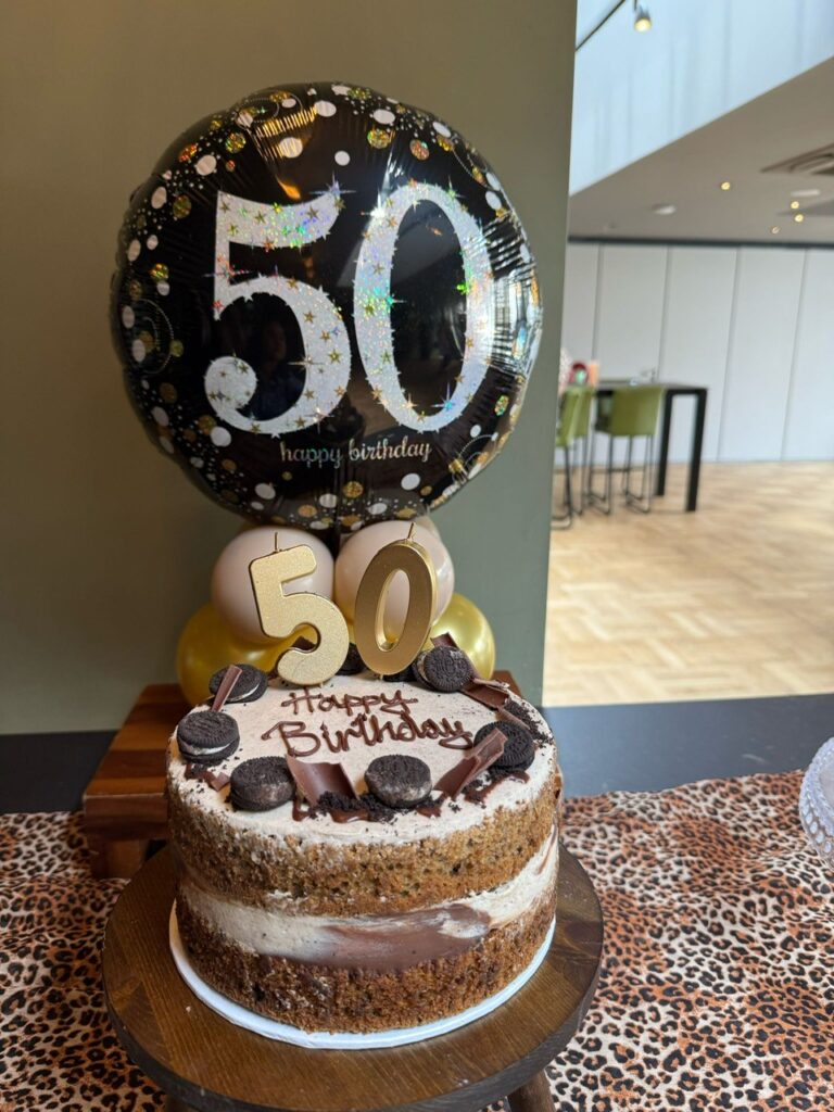 A 50th birthday cake and birthday balloon