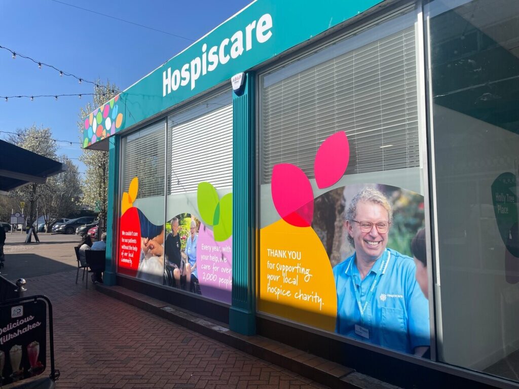The exterior of a Hospiscare building with vinyl decals of leaves and nurses