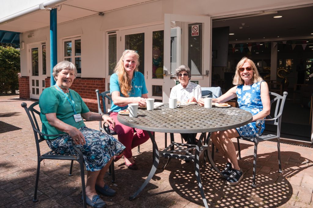 A group of women sat around a table in a garden